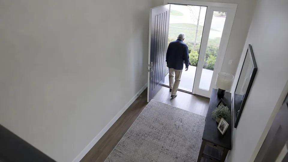 Entryway camera: an older man walking out through the open front door, no cane in hand.